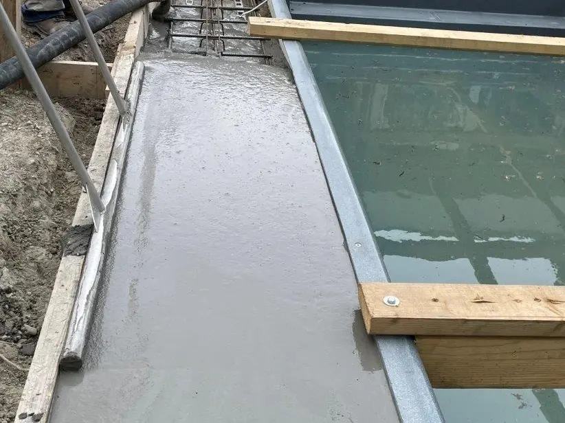  Le pourtour de la piscine est rempli de béton solide et lissé par un professionnel.