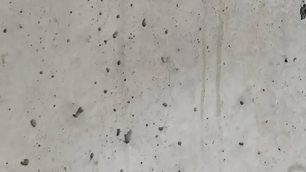 Detailaufnahme einer Betonwand mit kleinen Luftlöchern