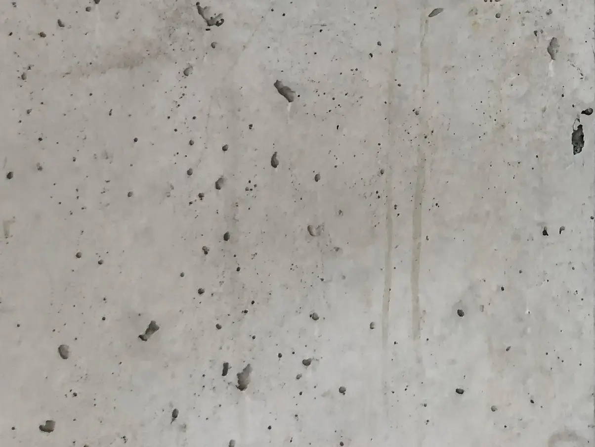 Detailansicht Betonoberfläche mit Lunkern und Ablaufspuren