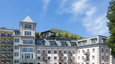 Hôtel de campagne historique par temps ensoleillé avec terrasse extérieure et crépi extérieur rose clair