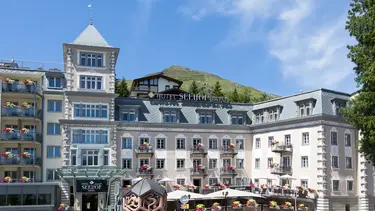 Hôtel de campagne historique par temps ensoleillé avec terrasse extérieure et crépi extérieur rose clair