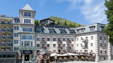 Hôtel de campagne historique par temps ensoleillé avec terrasse extérieure et crépi extérieur rose clair