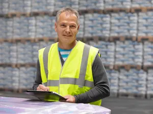 HASIT Logistic employee in front of several pallets with products