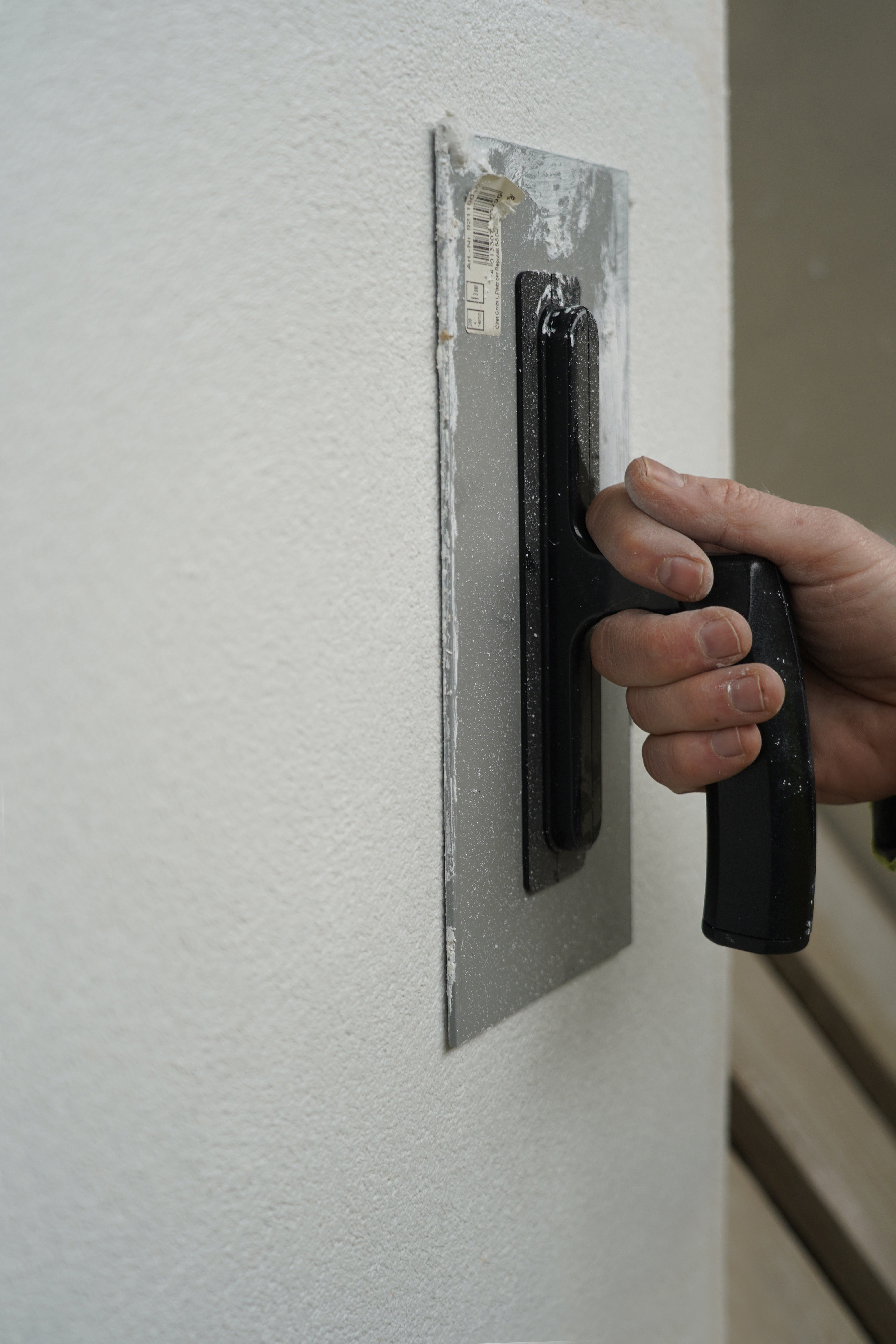 Strukturputz wird mit einer Kelle geglättet