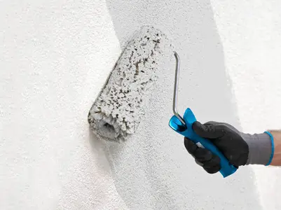 Hand mit Rolle streicht die Wand  