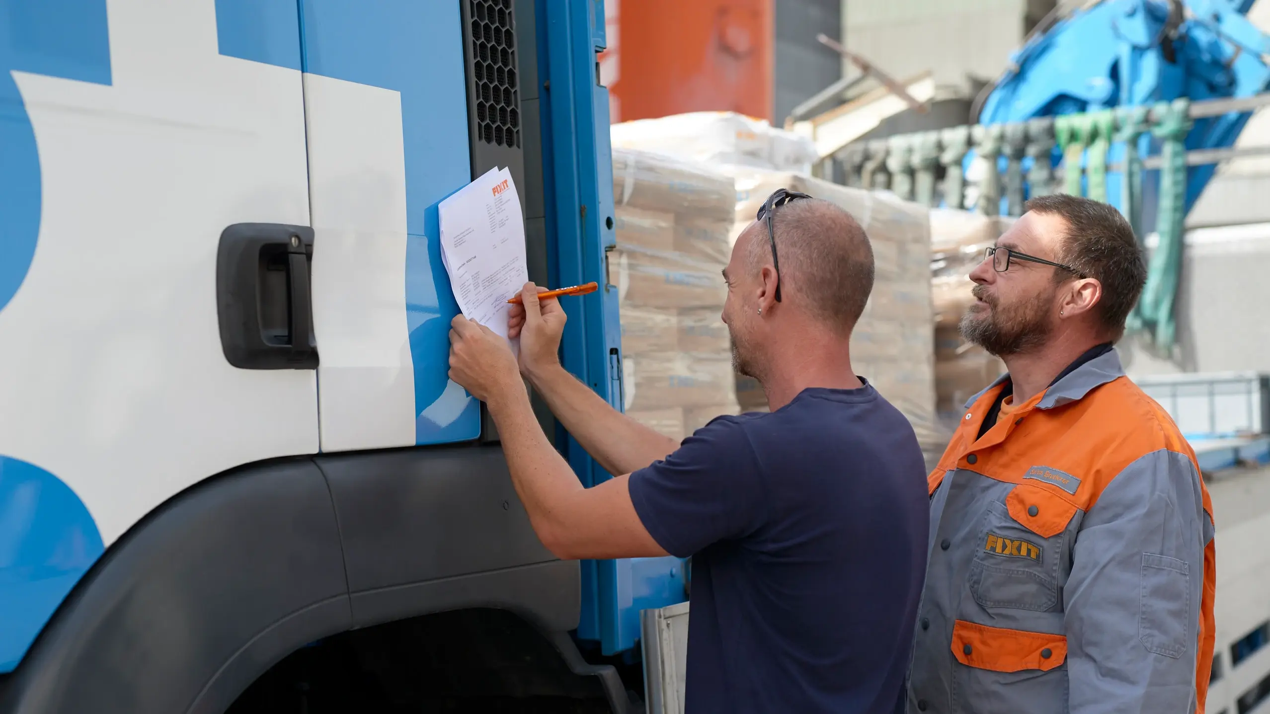 Fixit logistics employee hands over the goods to the lorry driver