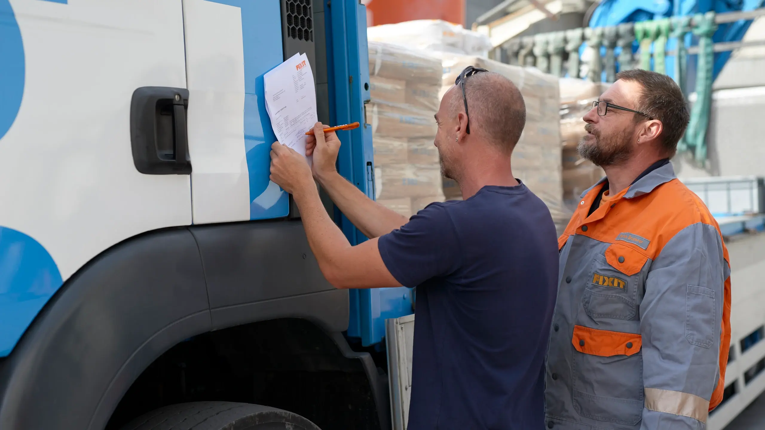 Le collaborateur logistique de Fixit remet la marchandise au chauffeur du camion