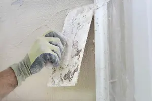 Hand mit Kelle verputzt die Wand 