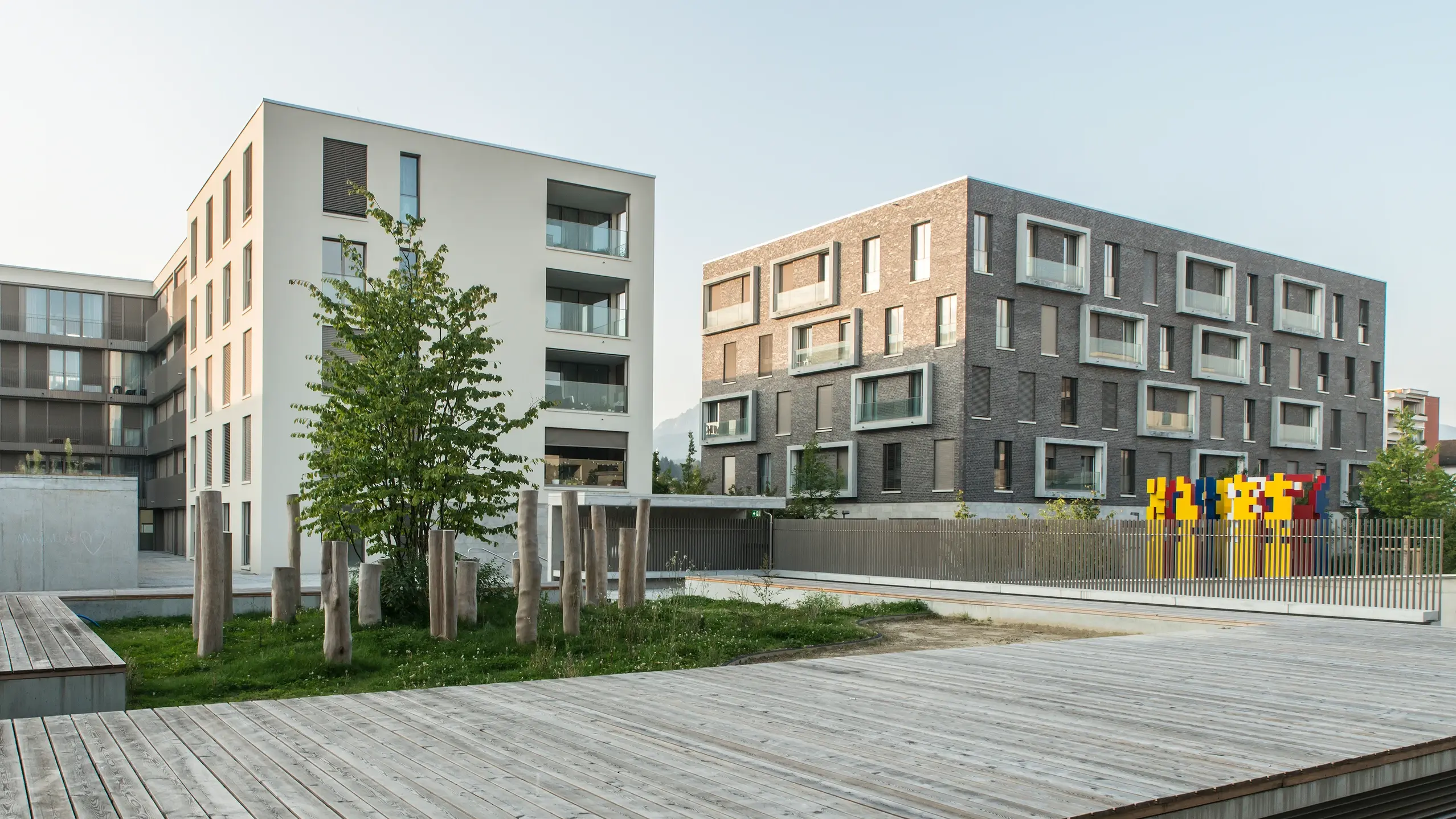 Two modern-style residential buildings and a wooden boardwalk