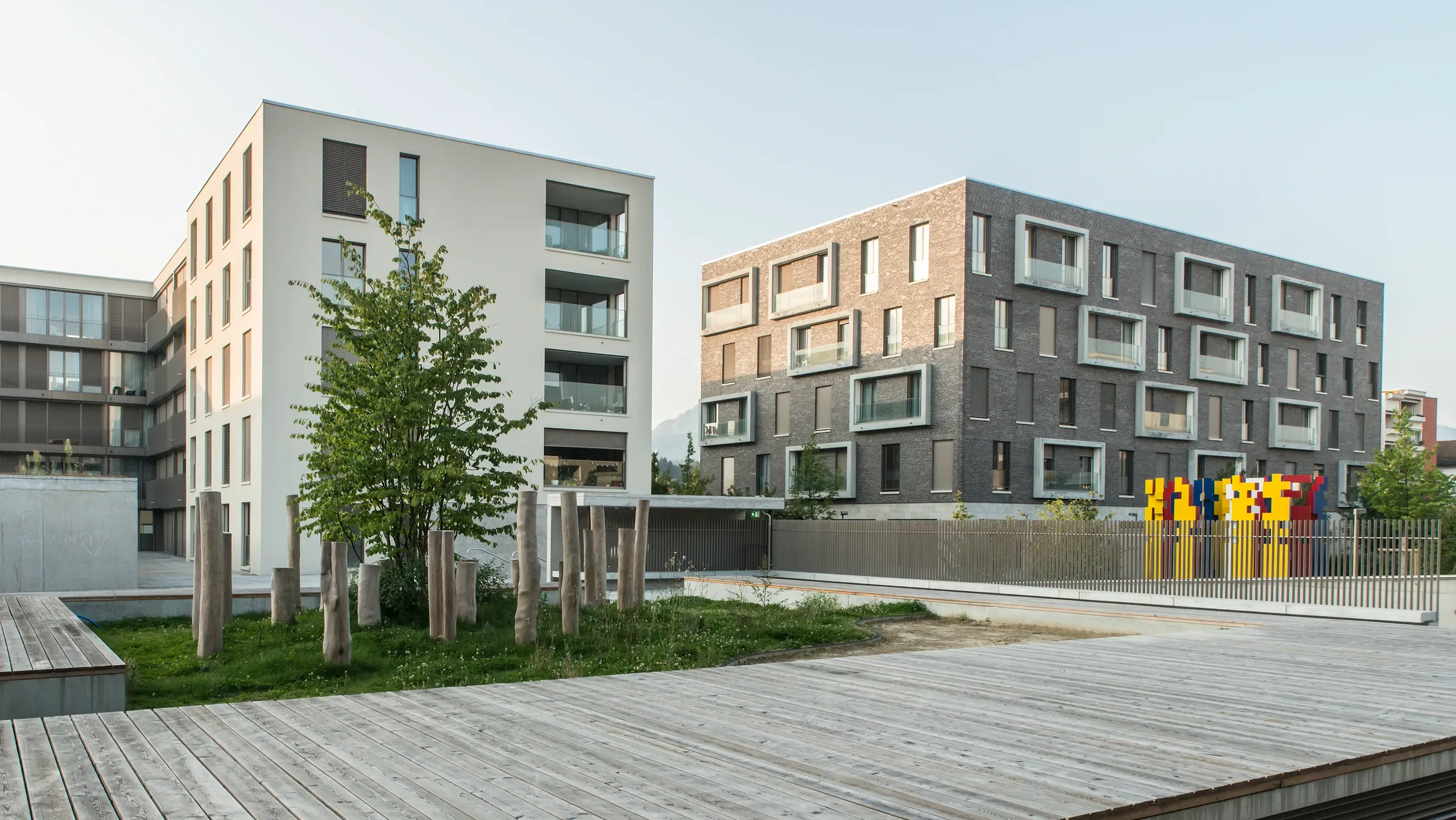 Zwei Mehrfamilienhäuser im modernen Stil und einem Weg aus Holzplanken