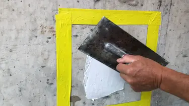 Abgeklebte Fläche für den Fixit Betoninspektor mit Spachtel aufgetragen