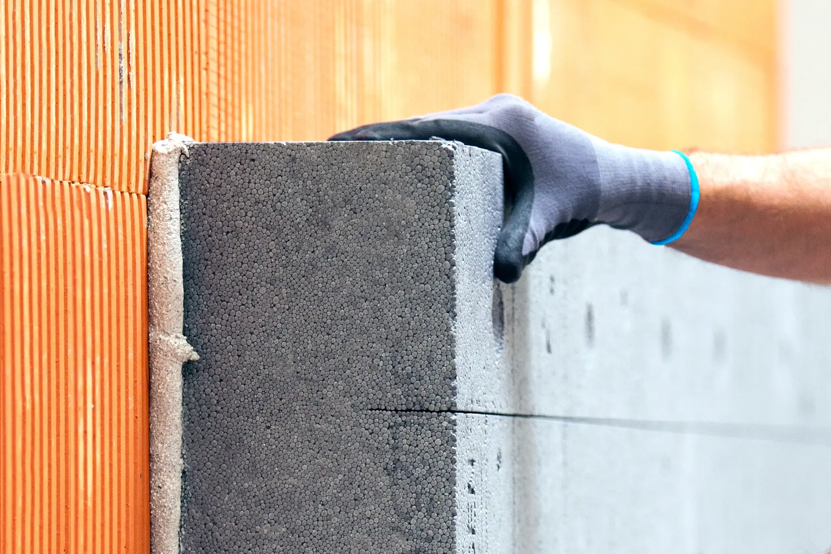Handliche - EPS-Platten werden auf den Ziegelwand geklebt 