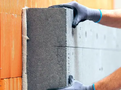 Handliche - EPS-Platten werden auf den Ziegelwand geklebt 