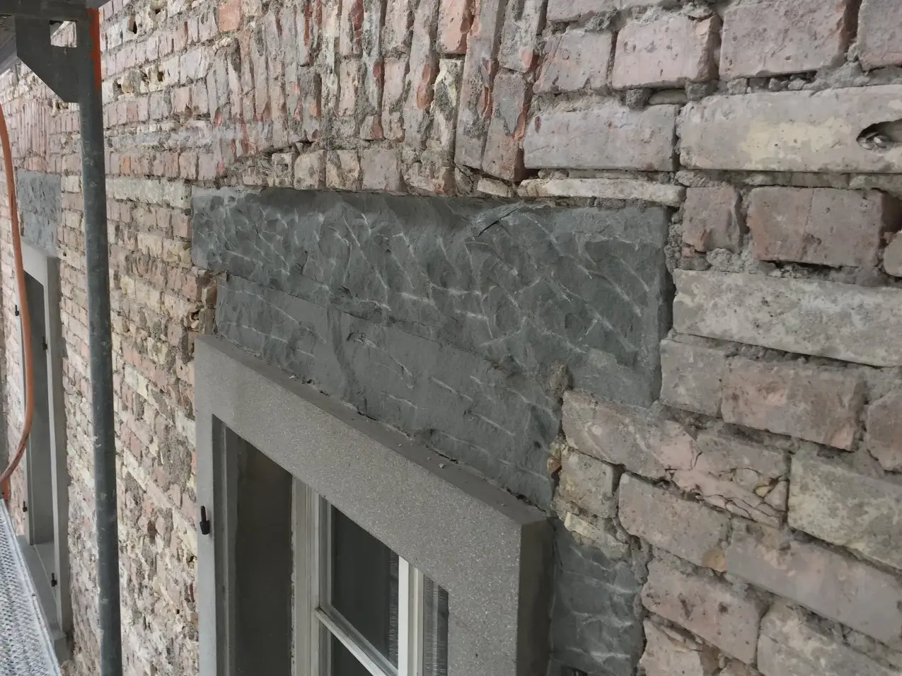 Dettaglio dell’architrave della finestra con muratura antica a vista e intradosso in pietra