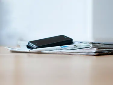 Mehrere Prospekte, darauf ein Handy und ein Stift von HASIT