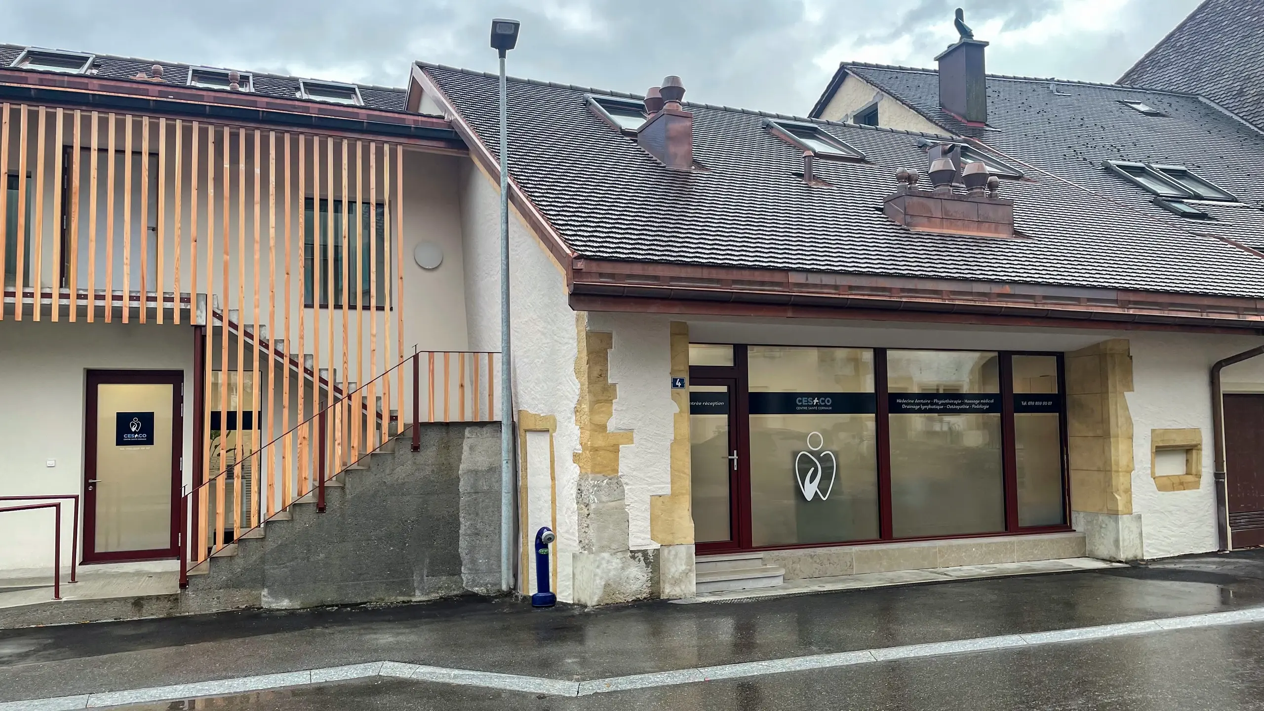 Links mit moderner Holzverkleidung und auf der rechten Seite weiss verputztes Haus mit Sandsteinbossen in Cornaux