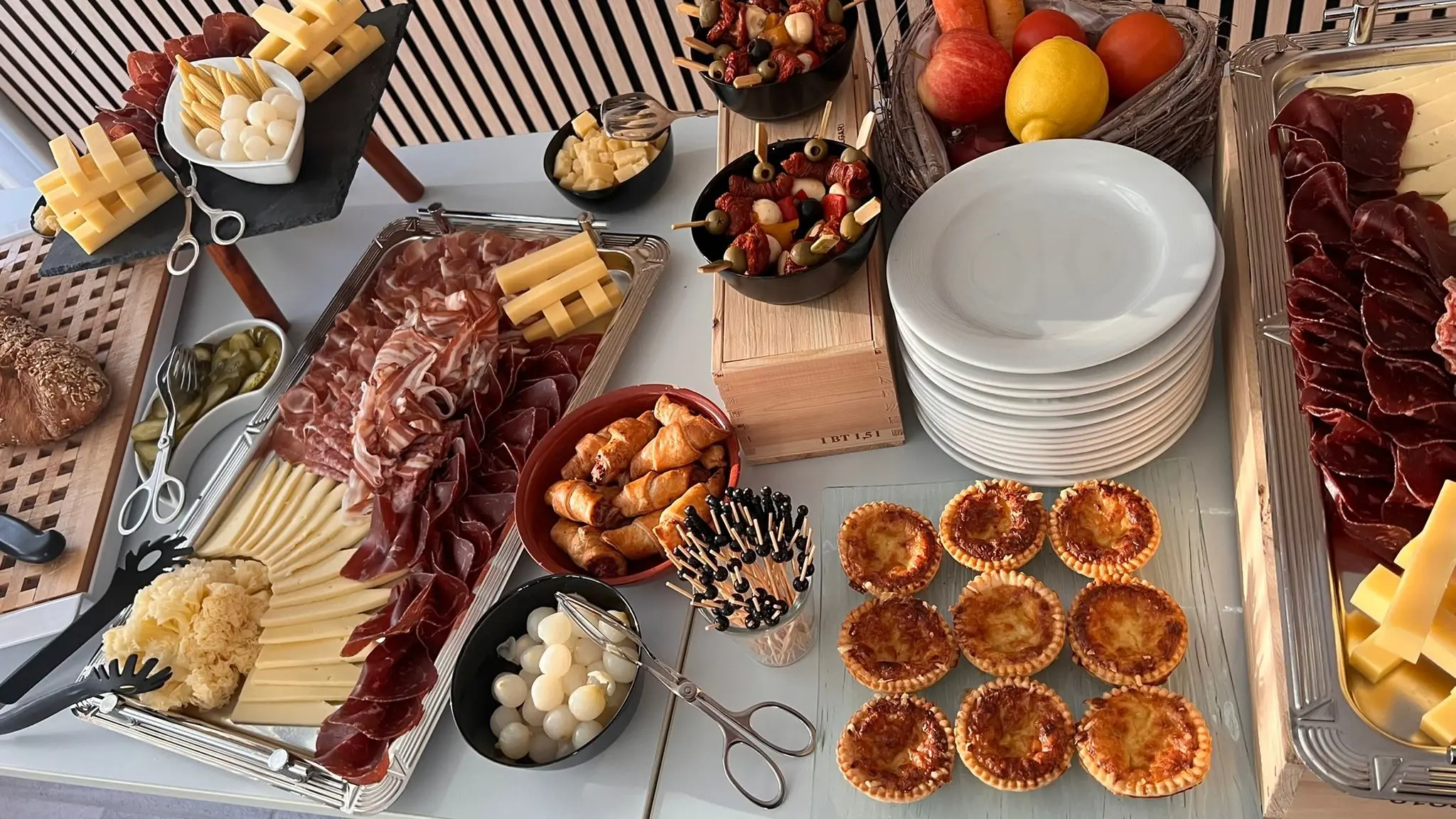 Viele verschiedene Fingerfood Platten, Chäsküchli, Salami und Fleischplatten, Käse und Silberzwiebeln ästhetisch arrangiert