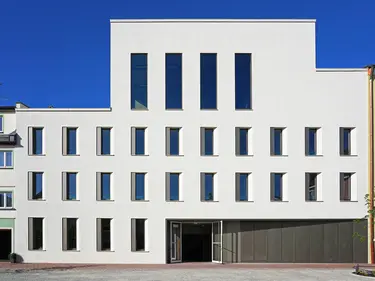 Ein modernes Haus mit großen Fenstern im Dachgeschoss.
