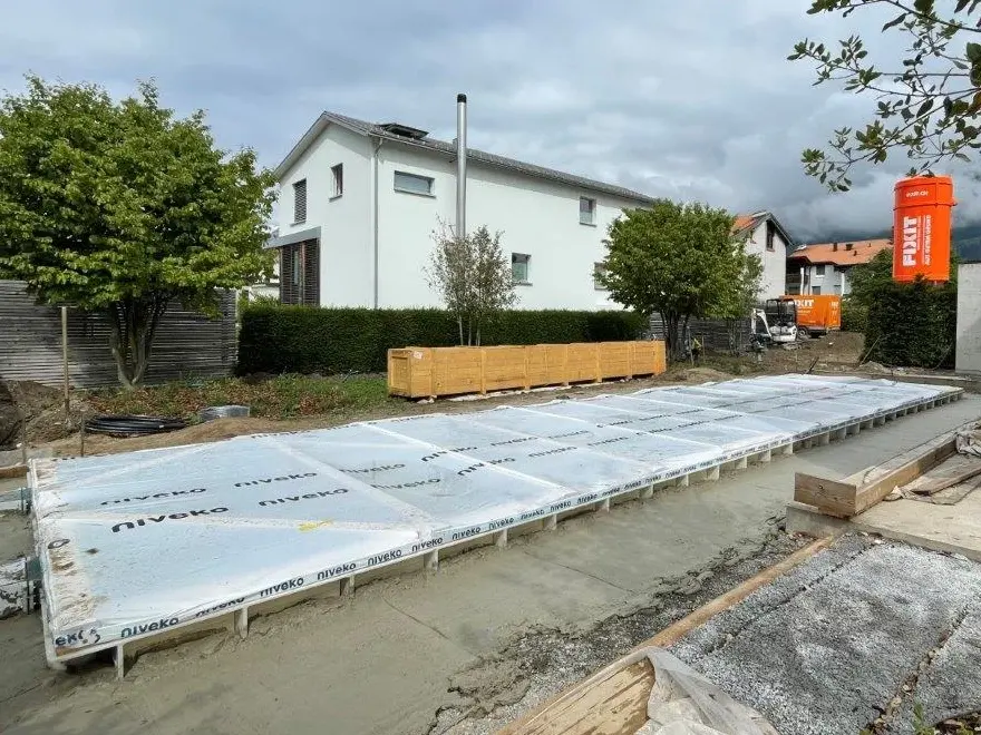 Le coffrage de la piscine est désormais entièrement rempli de béton cellulaire Fixit POR jusqu'au bord ; le silo Fixit orange se trouve à droite sur la photo.