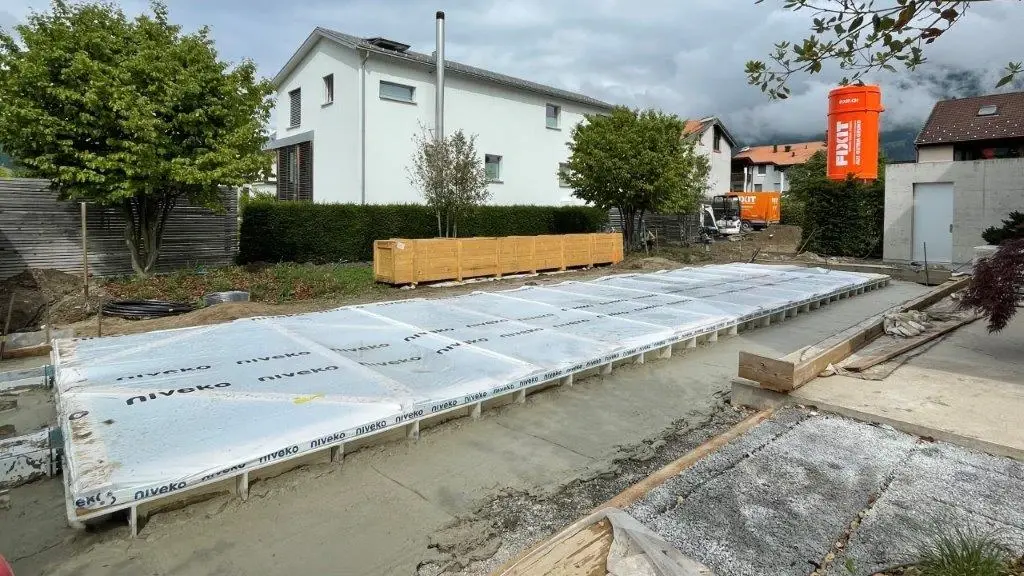  Le coffrage de la piscine est désormais entièrement rempli de béton cellulaire Fixit POR jusqu'au bord ; le silo Fixit orange se trouve à droite sur la photo.