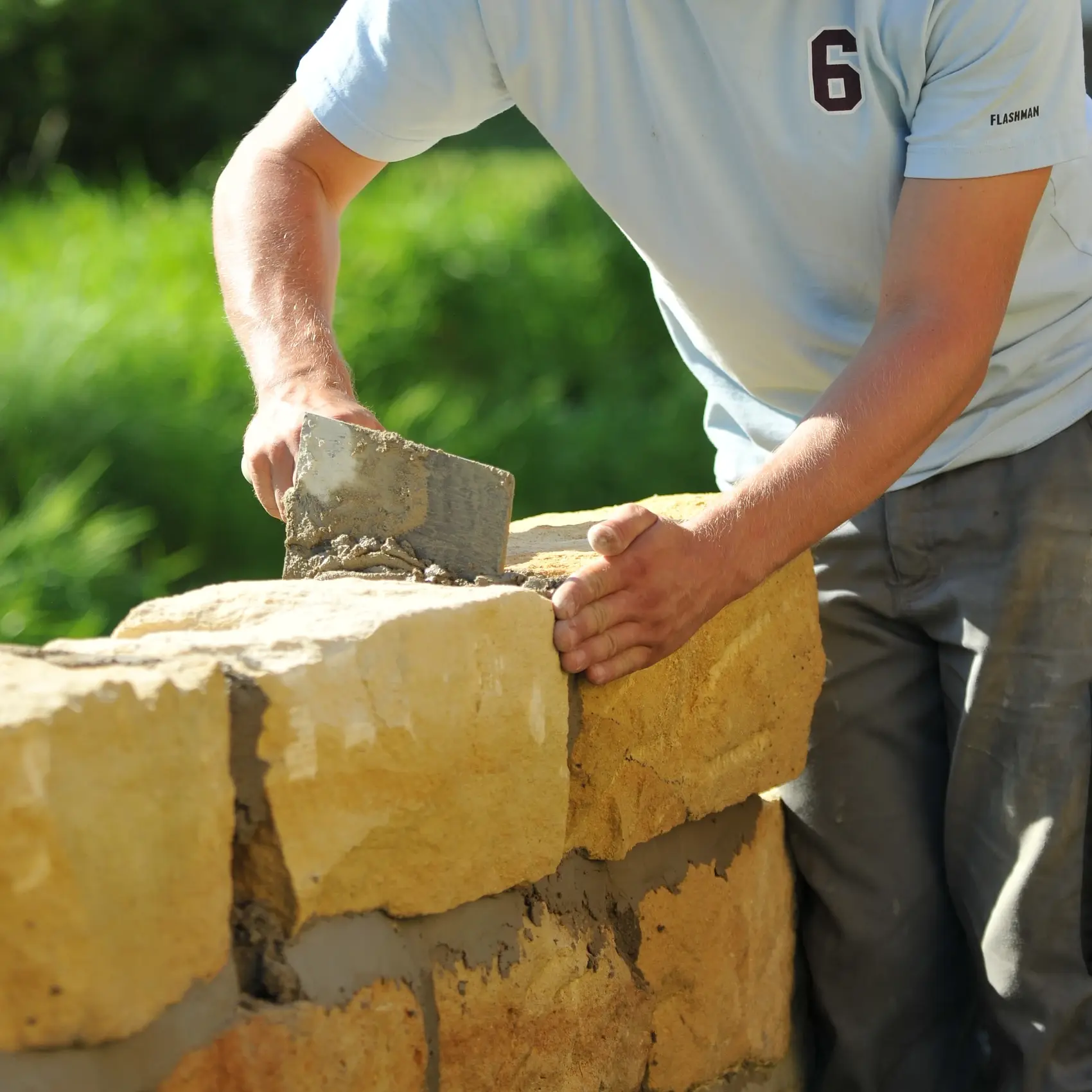 Eine Natursteinmauer wird mit Kalkmörtel gemauert