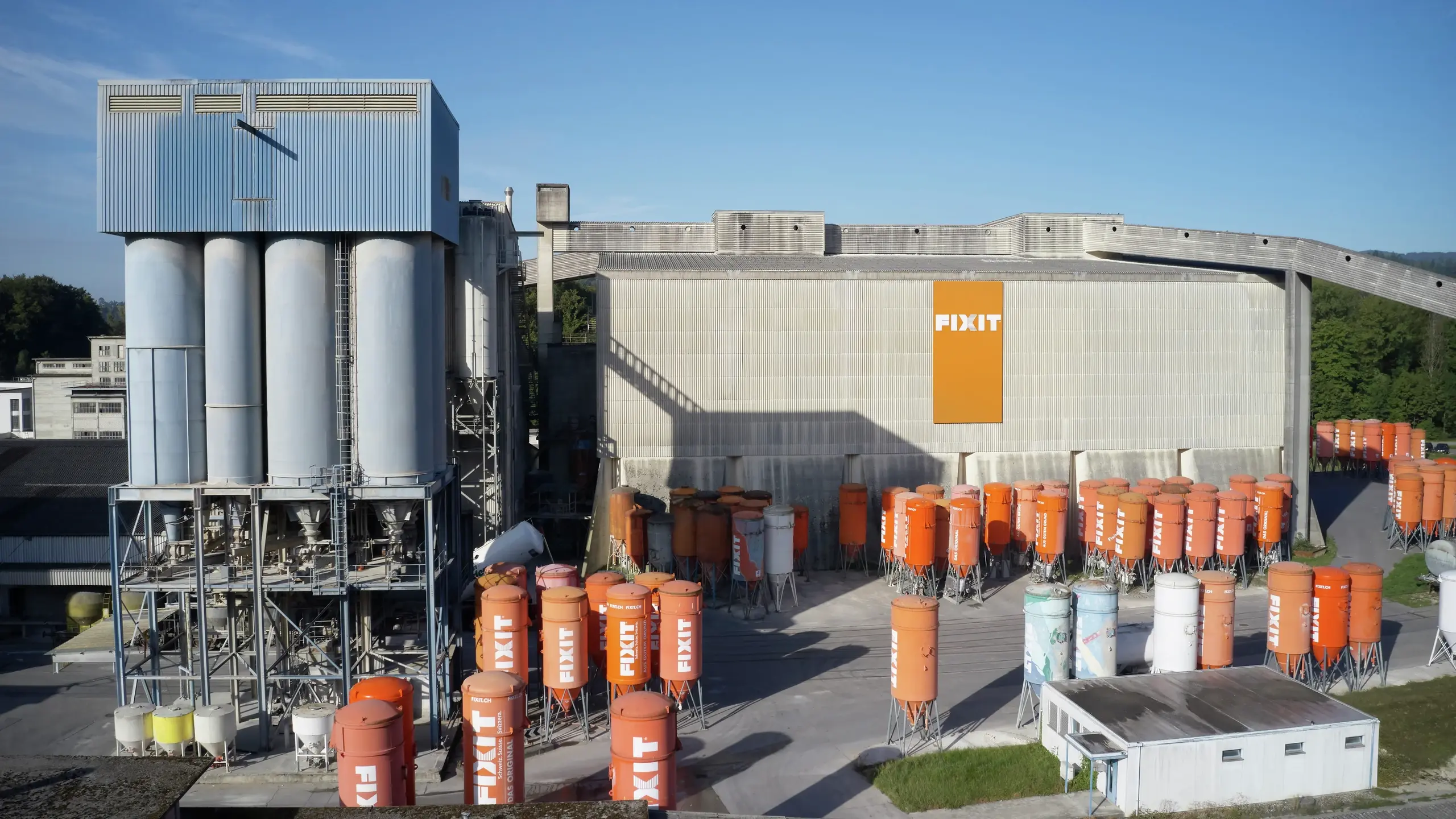 Hall de production et d'entreposage de Fixit AG à Holderbank (AG), avec de nombreux silos et de grandes tours de remplissage