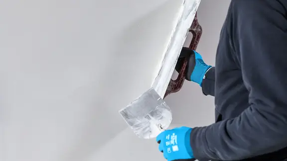 Verarbeiter verputzt eine Wand