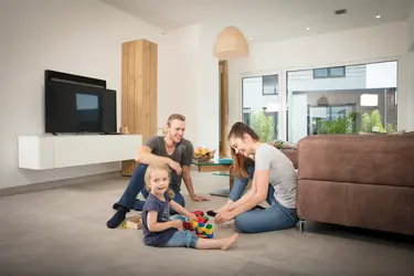 Die Familie unterhält sich fröhlich im Wohnzimmer am Boden