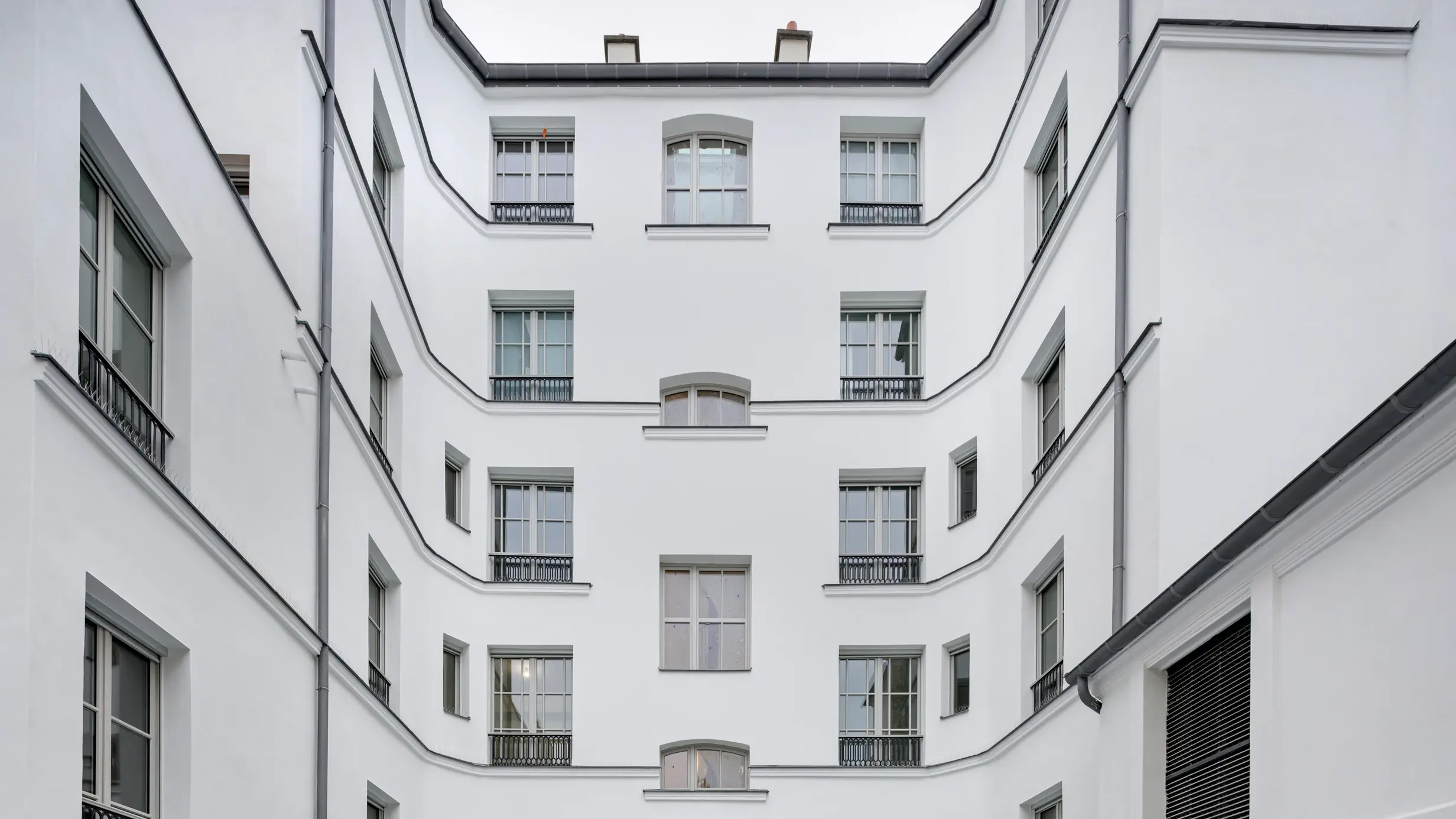 Storico condominio con facciata intonacata di bianco e isolata con intonaco isolante ad alte prestazioni Fixit 222 Aerogel. 