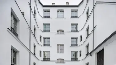  Immeuble historique avec façade crépie en blanc et isolée avec Fixit 222 Aerogel, enduit isolant haute performance.