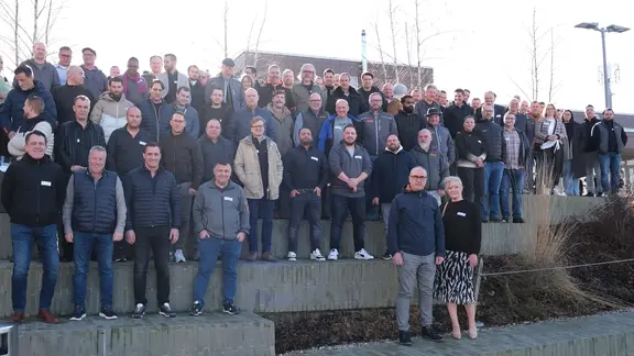 Photo de groupe de tous les participants sur les marches devant le parc de formation de Dagmersellen