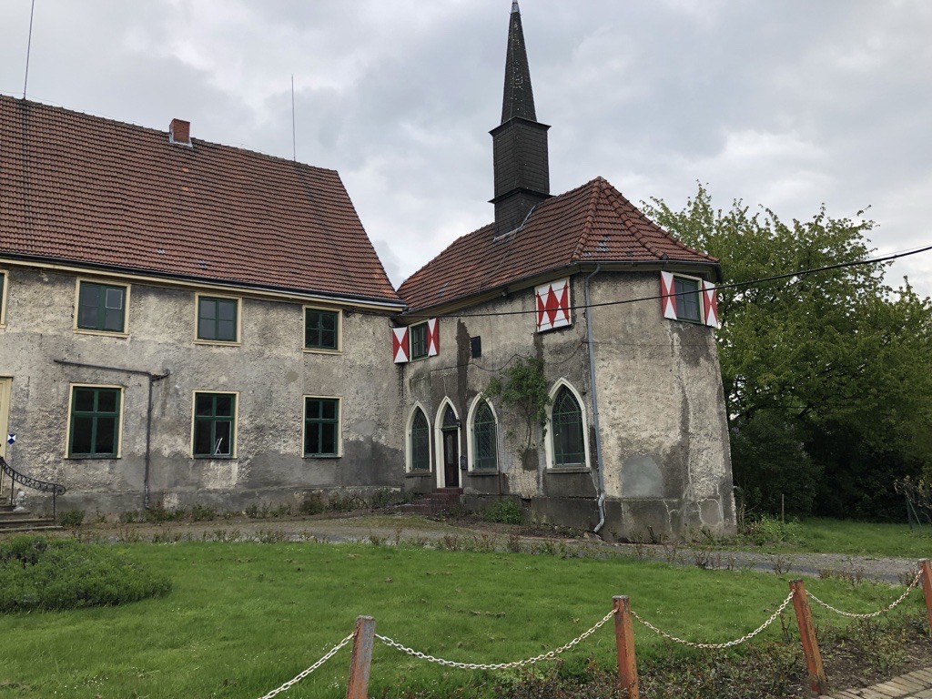 Rittergut Schafhausen vor der Sanierung – die Fassade wirkt stark heruntergekommen und zeigt deutliche Alterungsspuren.