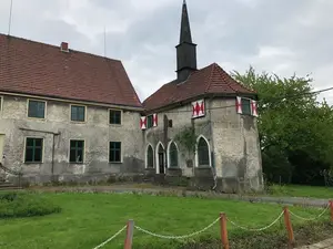 Rittergut Schafhausen vor der Sanierung – die Fassade wirkt stark heruntergekommen und zeigt deutliche Alterungsspuren.