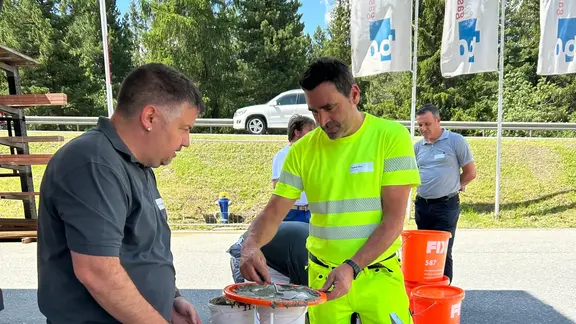 Remo Schwendener von Fixit zeigt ein Produkt aus Bereich Garten- und Landschaftsbau einem Besucher zum Testen