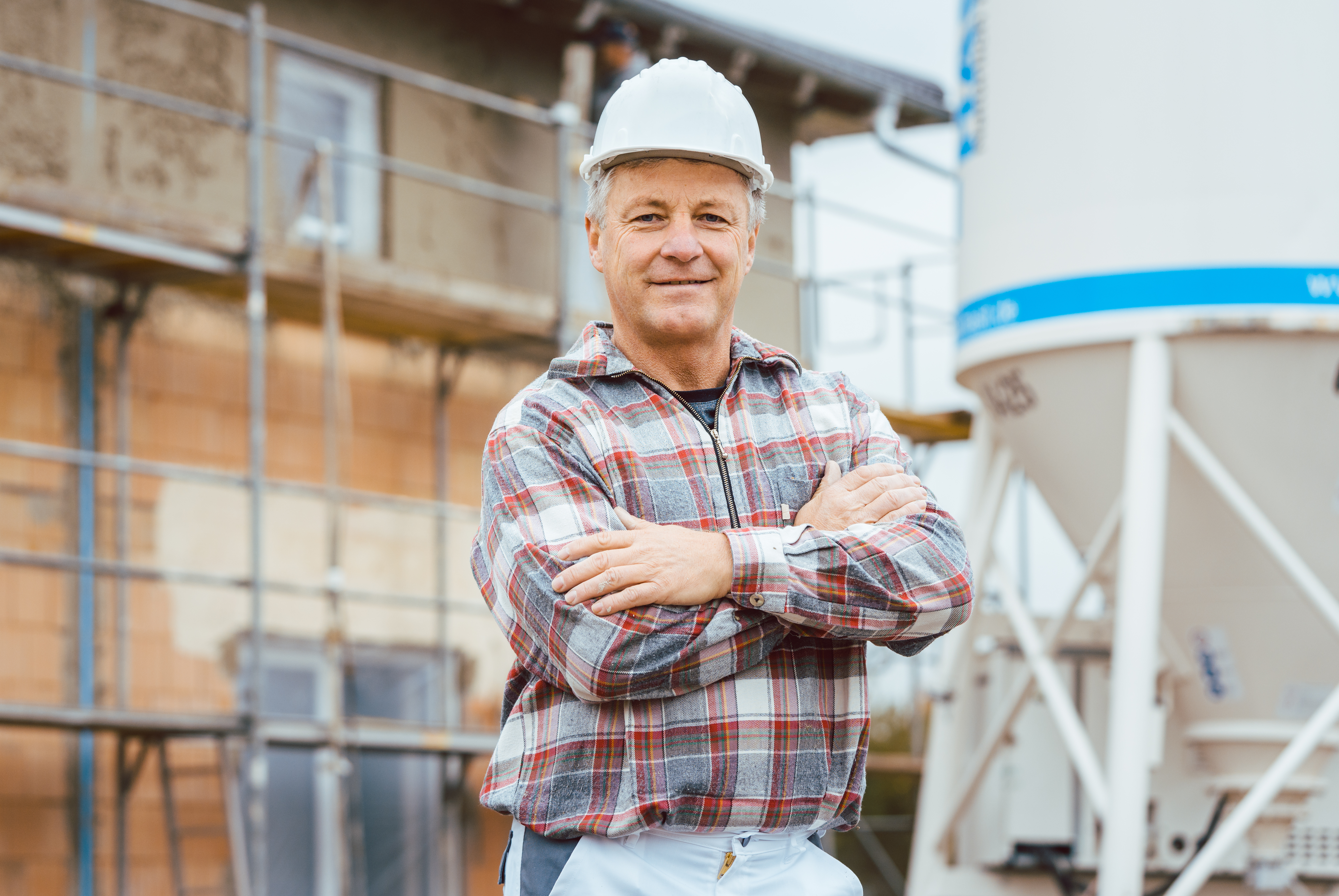 A worker stands in front of a silo.