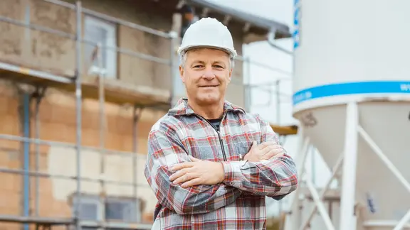 Ein Arbeiter steht vor einem Silo 