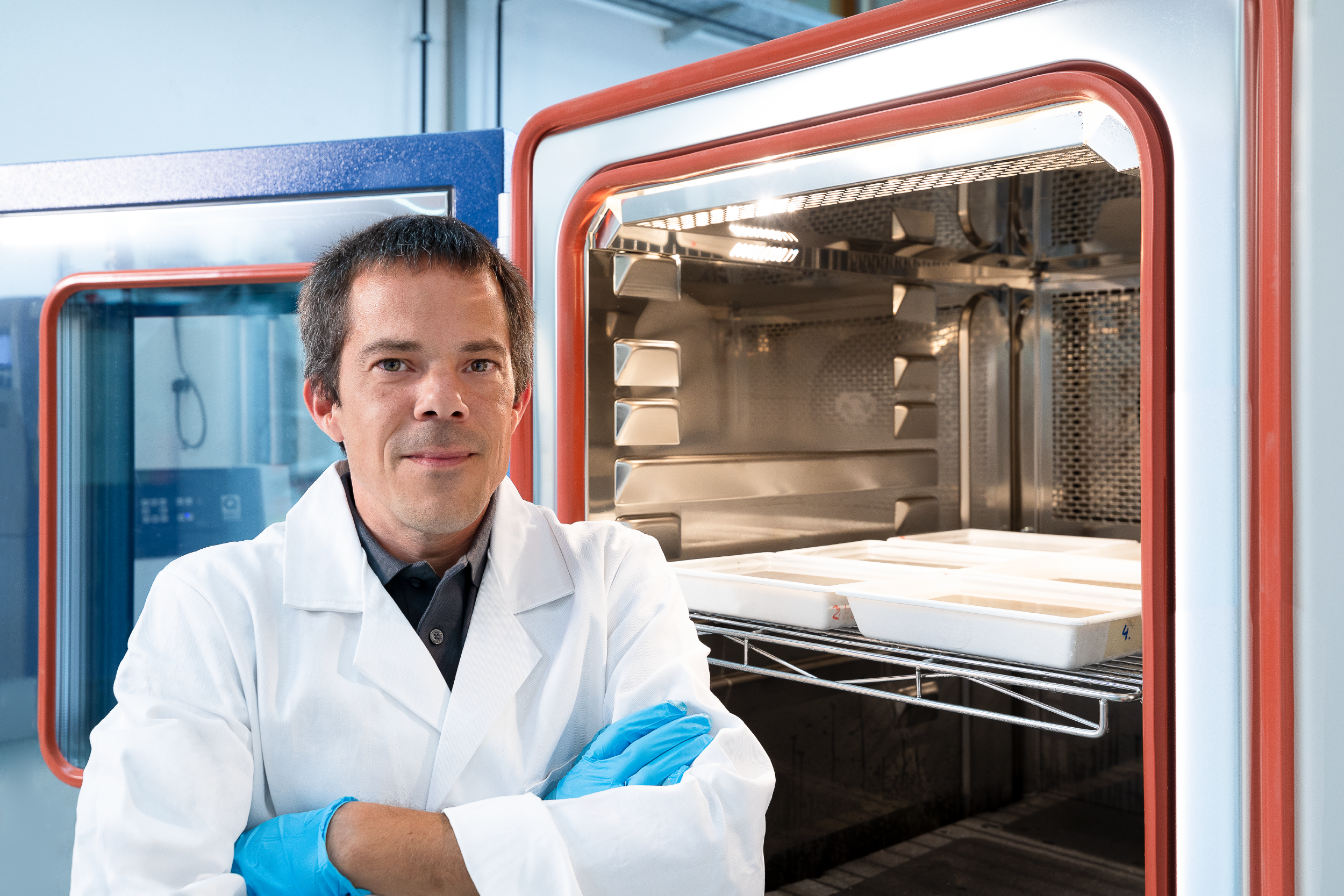 Ein Laborant steht vor einem Laborofen.