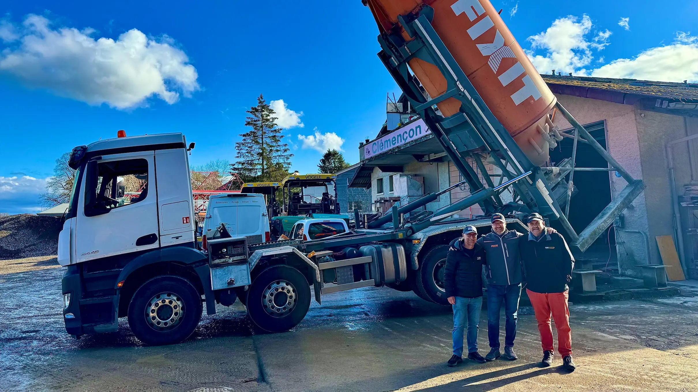 Drei Personen von BSC Constructions stehen vor dem Silo-LKW, während das Fixit Silo gerade aufgeladen wird