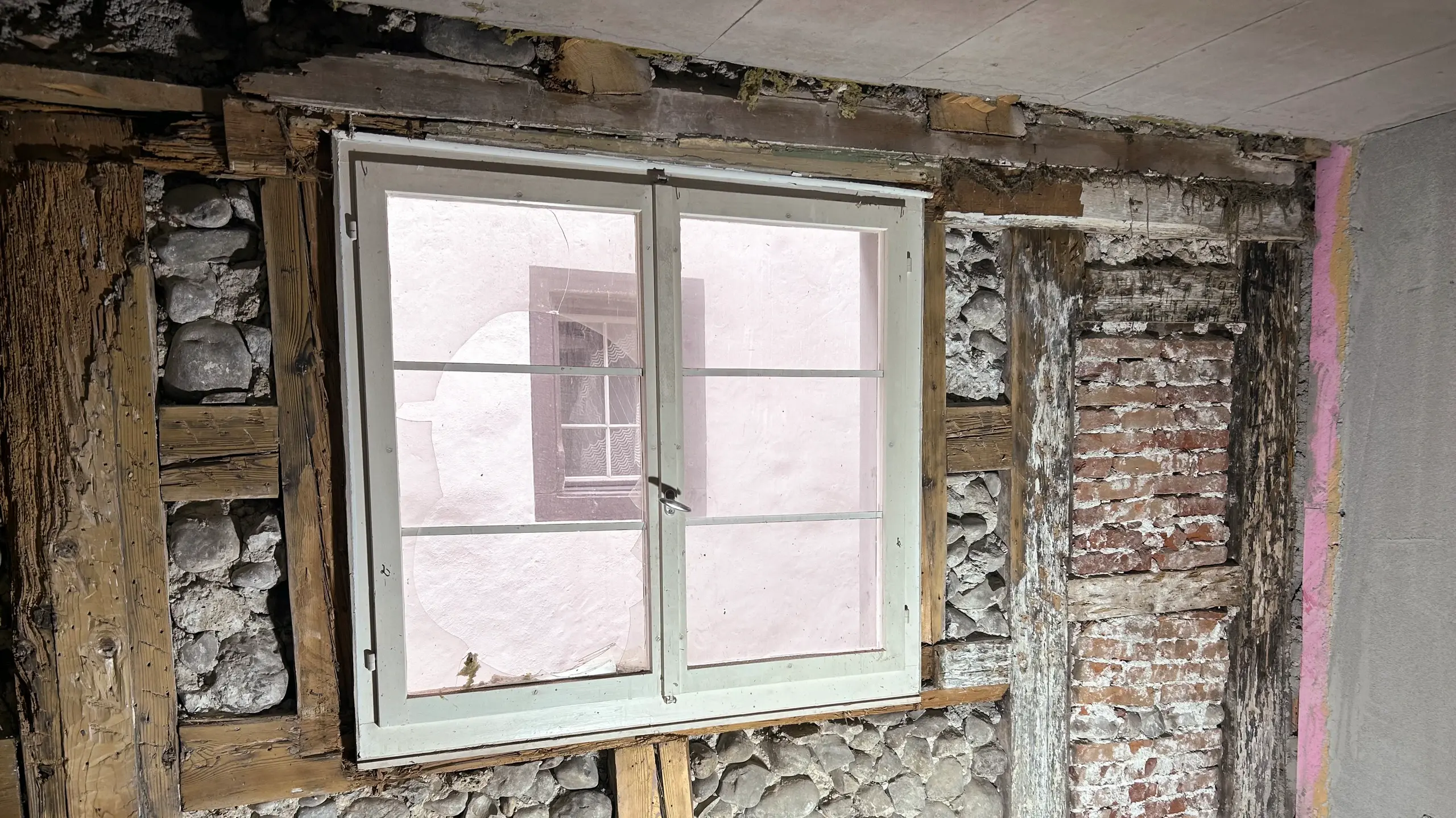 Mur extérieur historique avec protection du site, vue intérieure de la maçonnerie mise à jour et structure de poutres