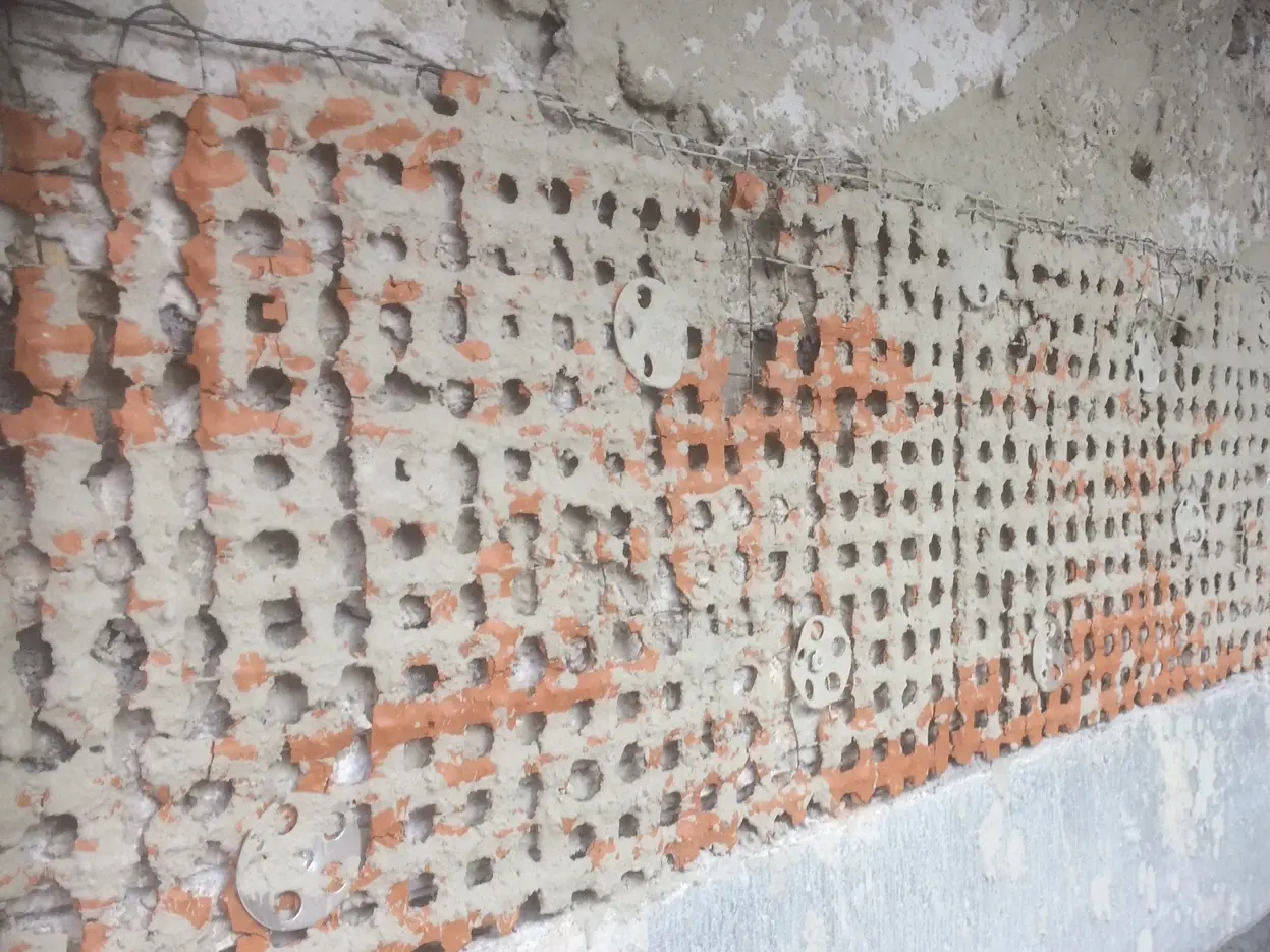 Detailansicht eines Ziegelrabitz Normgewebes mit teilweise überdeckten Tonelementen über einem Sturz