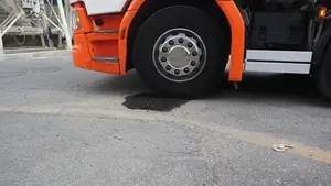 Ein Lkw fährt über einen frisch asphaltierten Straßenabschnitt.