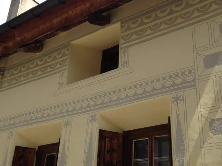 Sgraffito unter dem Dachrand und um die Fenster herum auf hellgelbem Aussenputz