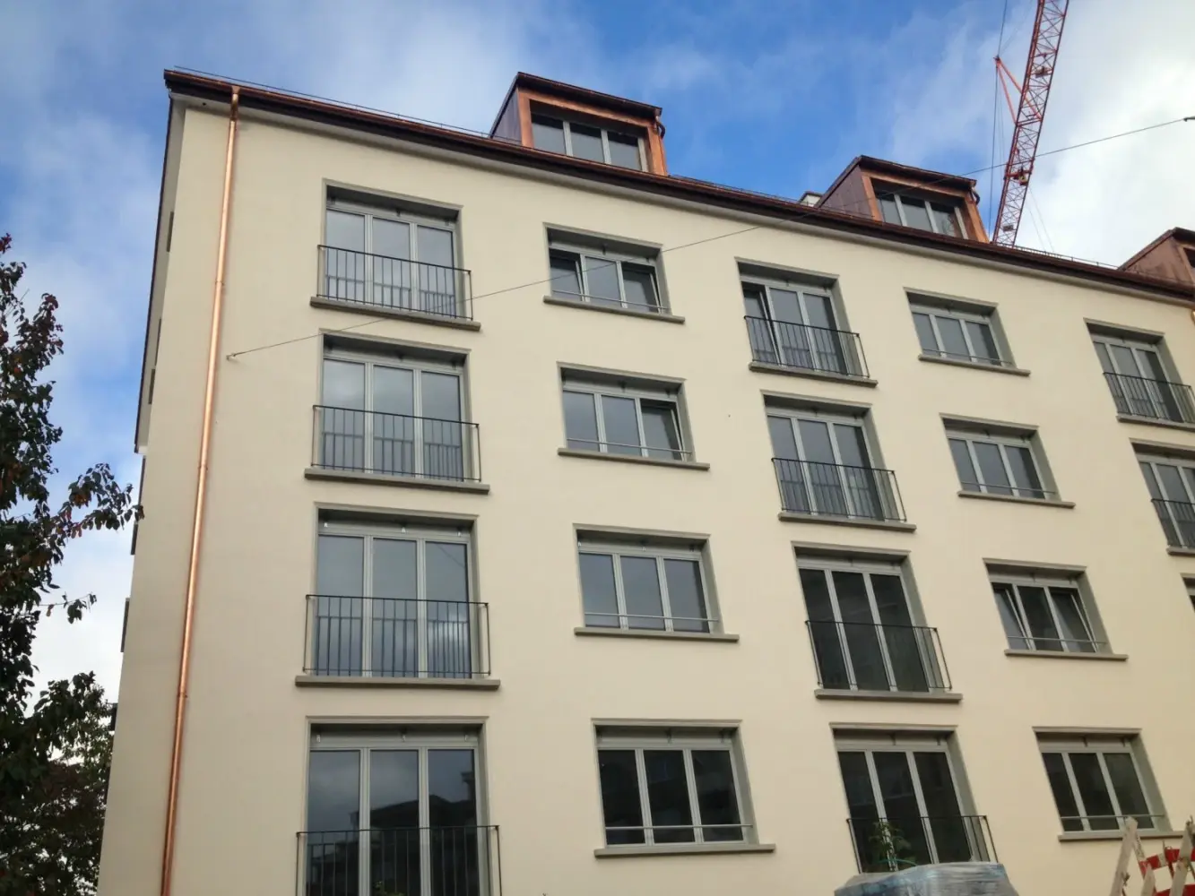 Aussenansicht des mehrstöcikigen Gebäudes nach der Sanierung mit Fixit 222 Aerogel und den neuen Balkonen und Kupferregenrohren