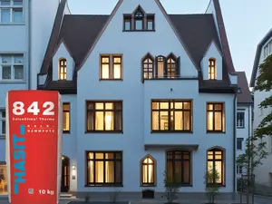 Renoviertes Haus mit Produktbild HASIT 842 Kalk-Dämmputz in Vordergrund