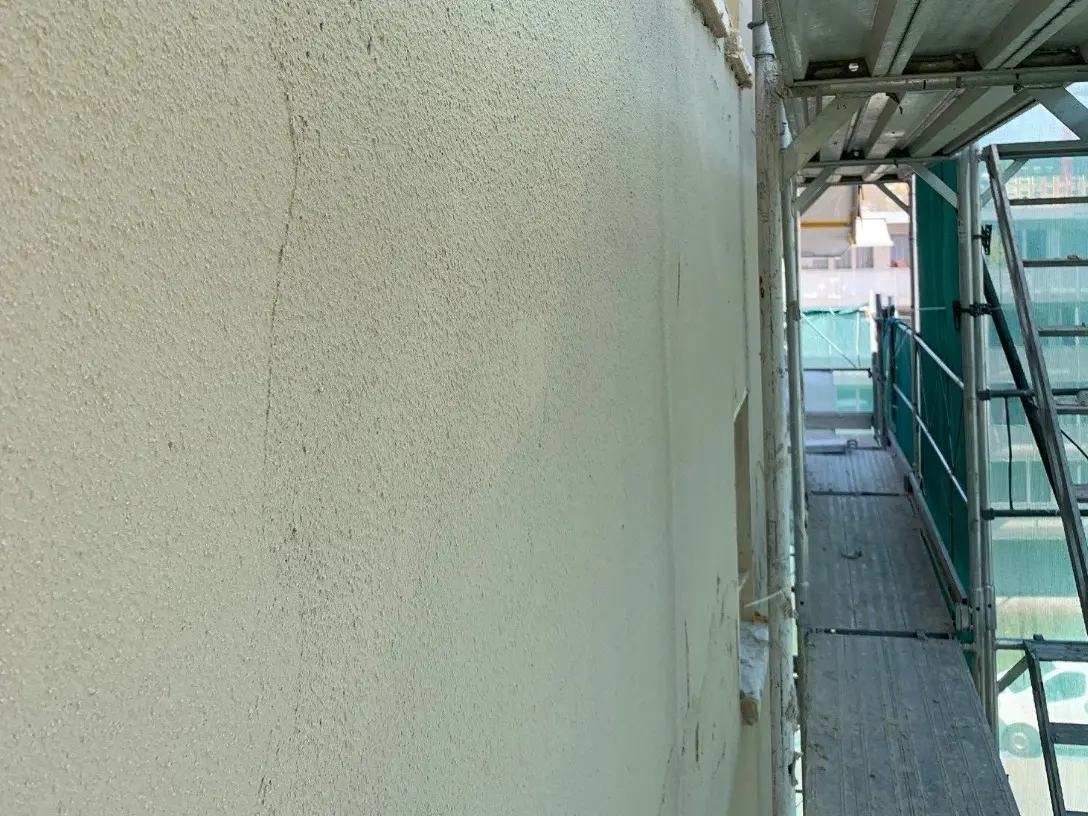 Un mur recouvert d'enduit isolant Fixit 222 Aerogel et d'échafaudages