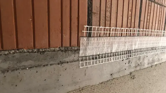 Materialübergang von einer Betonwand zu Ziegelsteinmauerwerk und bereits aufgeklebtem Stucanet® Easy Fix Entkopplungsband