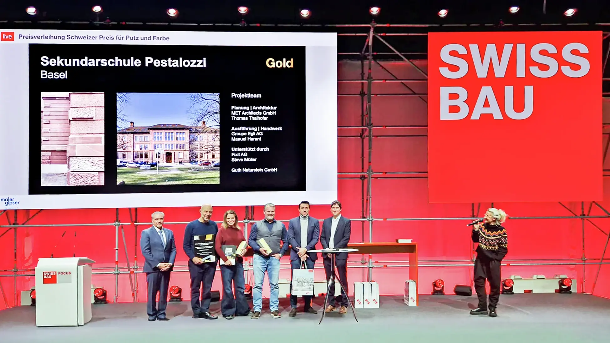 Die sechs Personen von Groupe Egli und MET Architects stehen auf der Swissbau Bühne und nehmen den Preis entgegen