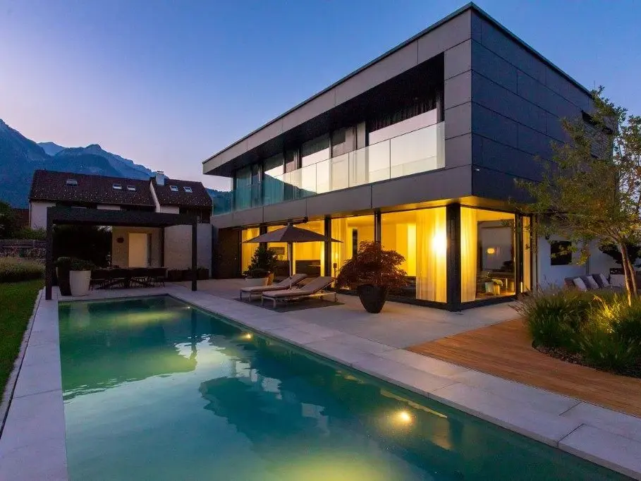  La piscine éclairée et l'immeuble résidentiel illuminé au crépuscule