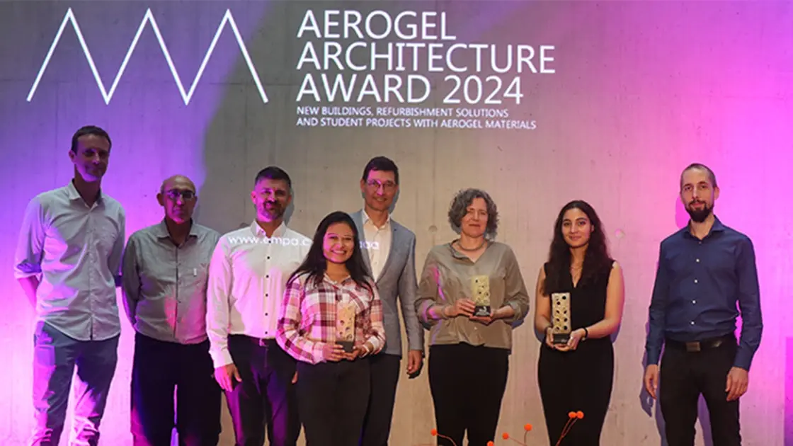 Gruppenfoto mit allen Gewinnern des AAA Aerogel Architecture Awards 2024 und pinkem Hintergrund mit Logo