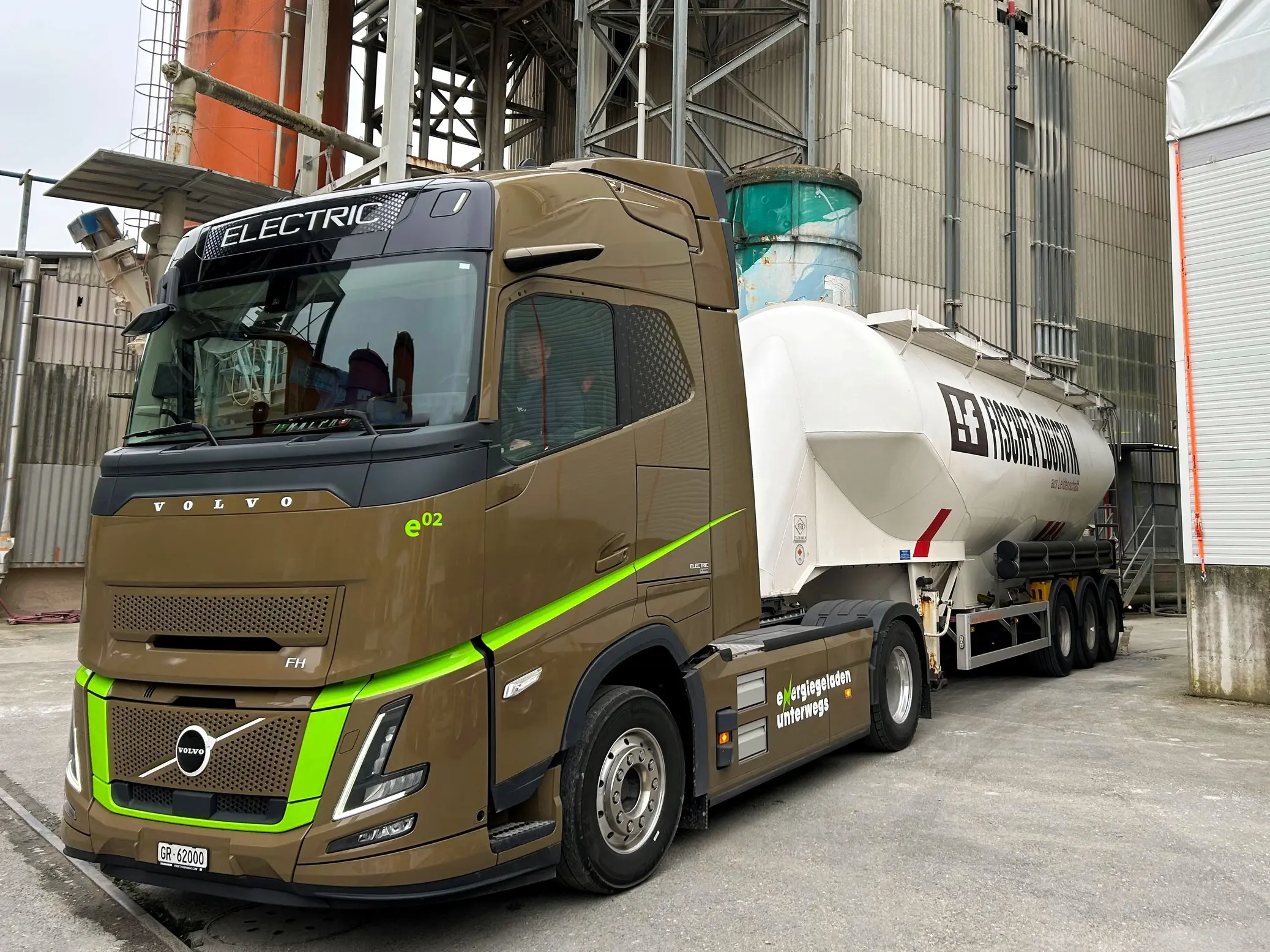 Le camion électrique de Fischer Logistik, équipé d'une semi-remorque-silo, est stationné devant le hall de production à Holderbank
